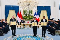 Seremoni MoU showing antara PLN, PT SMI, dan HDF Energy terkait Pendanaan Pengembangan Hidrogen di Indonesia yang dilakukan oleh Direktur Utama PLN, Darmawan Prasodjo (kanan), Direktur Utama PT SMI, Reynaldi Hermansjah (tengah), dan Chief Executive Officer of Hydrogen de France SA, Damien Havard (kiri) di hadapan Presiden RI, Prabowo Subianto (kanan belakang) dan Presiden Prancis, Emmanuel Macron (kiri belakang) pada Rabu, (28/5) di Istana Kepresidenan RI. Foto: BPMI Setpres.