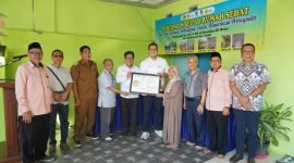 Yuni Endang Wiludjeng (berhijab) menerima pigura yang menandai serah terima rumahnya pada Senin (7/6) di Gresik setelah direnovasi melalui program Bedah Rumah Sehat yang diadakan PLN Nusantara Power berkolaborasi dengan LAZIS PLN NP dan IKPLN.