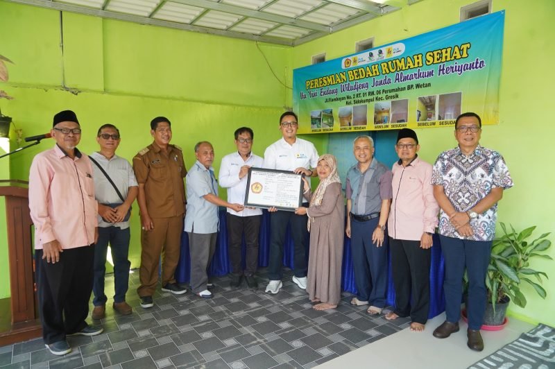 Yuni Endang Wiludjeng (berhijab) menerima pigura yang menandai serah terima rumahnya pada Senin (7/6) di Gresik setelah direnovasi melalui program Bedah Rumah Sehat yang diadakan PLN Nusantara Power berkolaborasi dengan LAZIS PLN NP dan IKPLN.