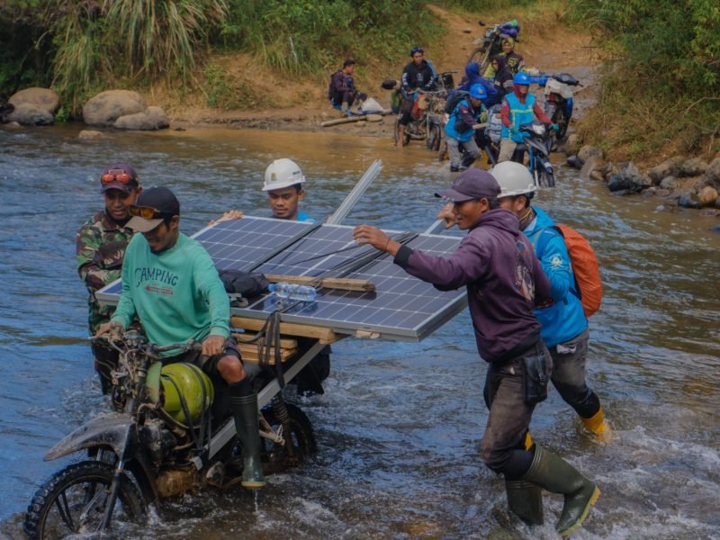 Petugas PLN bersama warga bahu-membahu membawa panel surya melintasi sungai. Upaya ini menjadi bagian dari perjalanan Program Listrik Desa (Lisdes) melalui SuperSUN dalam menghadirkan akses listrik bagi warga di Kecamatan Seko, Luwu Utara, Sulawesi Selatan.