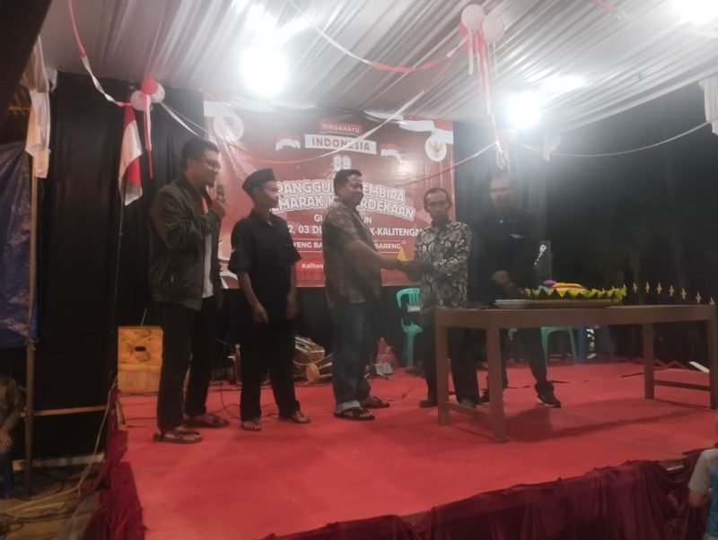 Foto: Momen pemotongan tumpeng malam puncak HUT RI ke-80 bersama Satimin (Kepala Desa Kali Tengah) dan Saimun (tokoh masyarakat).