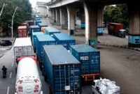 Antrean truk kontainer menuju Pelabuhan Tanjung Priok untuk bongkar-muat menimbulkan kemacetan di Jl. Jampea Raya, Jakarta Utara. Di balik klaim fleksibilitas, sopir trailer sebenarnya menunggu tanpa jeda, siap dipanggil kapan saja tanpa kepastian istirahat. (Dok: Project M/Henry)