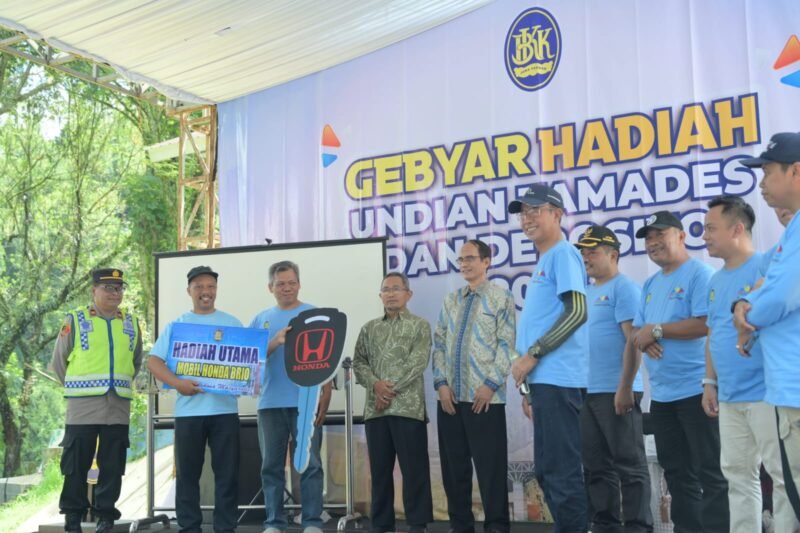 Riyanti Raih Mobil Honda Brio dalam Kemeriahan Gebyar Hadiah Undian BKK Mandiraja di Serulingmas

BANJARNEGARA- Suasana haru dan bahagia terpancar dari wajah Riyanti, seorang nasabah setia asal Desa Banjengan, Kecamatan Mandiraja, saat namanya diumumkan sebagai pemenang hadiah utama satu unit mobil Honda Brio Satya. 
Momen istimewa ini menjadi puncak acara Gebyar Hadiah Undian Tamades dan Deposito Tahun 2026 yang diselenggarakan oleh PT BPR BKK Mandiraja (Perseroda) di Taman Rekreasi Marga Satwa (TRMS) Serulingmas pada Minggu, 12 April 2026.
Kemeriahan acara sudah terasa sejak pagi hari, diawali dengan kegiatan jalan sehat yang diikuti secara antusias oleh jajaran direksi, karyawan, keluarga besar BPR BKK Mandiraja, hingga masyarakat luas. Selain hadiah utama berupa mobil, pihak bank juga memanjakan nasabahnya dengan beragam hadiah fantastis lainnya, mulai dari 16 unit sepeda motor, 16 unit TV LED, hingga puluhan perangkat elektronik seperti kulkas, mesin cuci, dan sepeda gunung.
Dalam laporannya, Plt Direktur Utama BPR BKK Mandiraja, Tri Ristanto Budiono SE, M.Si, mengungkapkan bahwa pertumbuhan bank menunjukkan tren yang sangat positif. Hingga Maret 2026, aset bank telah menyentuh angka Rp605 miliar, mengalami kenaikan signifikan sebesar Rp114 miliar dibandingkan tahun sebelumnya. 
Sementara itu, total tabungan masyarakat juga melonjak hingga Rp282 miliar. Tri Ristanto menekankan bahwa pemilihan Serulingmas sebagai lokasi acara bertujuan untuk memperkuat sinergi sesama Badan Usaha Milik Daerah (BUMD) sekaligus mendukung promosi pariwisata lokal Banjarnegara.
Dukungan penuh juga datang dari Pemerintah Kabupaten Banjarnegara. Pj Sekda Banjarnegara, Tursiman S.Sos, mengapresiasi peran besar BPR BKK Mandiraja dalam memutar roda ekonomi daerah. 
Menurutnya, dengan menabung di bank milik pemerintah, masyarakat secara tidak langsung turut membangun daerahnya sendiri karena keuntungan bank akan kembali ke kas daerah dalam bentuk dividen. Harapan senada disampaikan oleh Bupati Banjarnegara, dr. Amalia Desiana, yang menginginkan agar sinergi ini terus meningkatkan kesejahteraan masyarakat melalui inovasi layanan keuangan.
Menanggapi keamanan dana nasabah, Komisaris Utama PT BPR BKK Jateng, Masrofi, meyakinkan masyarakat untuk tidak ragu menyimpan uang mereka di BKK Mandiraja. Ia menegaskan bahwa selain dikelola secara profesional oleh pemerintah provinsi dan kabupaten, seluruh dana nasabah telah dijamin sepenuhnya oleh Lembaga Penjamin Simpanan (LPS). 
Proses pengundian pun dilakukan secara transparan dengan pengawasan ketat dari notaris, kepolisian, dan Dinas Sosial, memastikan seluruh rangkaian acara berjalan adil hingga penutupan yang diwarnai dengan pembagian puluhan doorprize bagi peserta jalan sehat.(BS)


Riyanti nasabah dari Desa Banjengan Mandiraja mendapat hadiah utama Mobil Brio Satya pada Gebyar Hadiah Undian Tamades BPR BKK Mandiraja . Hadiah di berikan oleh Komisaris Utama BPR BKK Jawa Tengah (Perseroda) diterima kepala kantor cabang Mandiraja
(foto/doc)